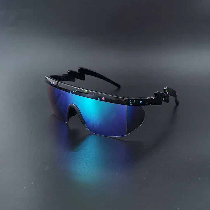 Futuristic sport sunglasses with blue mirrored lenses, a black zigzag frame, and small colorful dots on the frame, displayed on a dark reflective surface. Perfect for those seeking stylish bicycle eyewear.