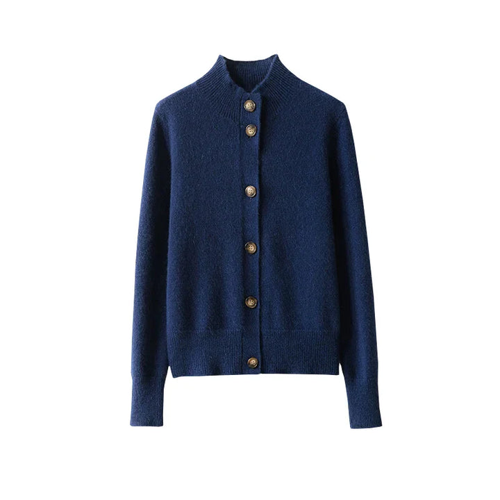 A navy blue, long-sleeve, ultra soft cashmere cardigan with a ribbed collar, cuffs, and hem, featuring a row of brown buttons down the front. The 100% wool cashmere piece is displayed on a white background.