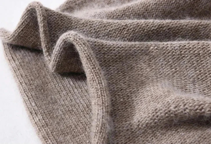 A close-up view of a soft, light brown knitted fabric with visible texture and gentle folds, showcasing its cozy, lightweight material—perfect for a slouchy beanie.