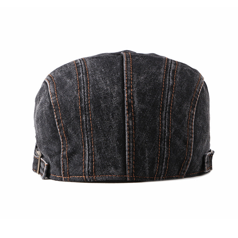 A black premium denim flat cap viewed from the back, featuring vertical brown stitching and adjustable straps on both sides.