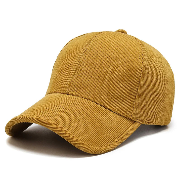 A mustard yellow corduroy baseball cap with a curved brim, this stylish piece stands out among retro hats and adds a classic touch to any collection of corduroy hats. Displayed against a plain white background.