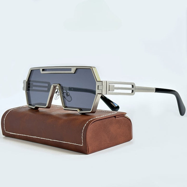Geometric, oversized Steampunk Sunglasses with metallic square frames and dark lenses are displayed on a brown leather case against a light background.