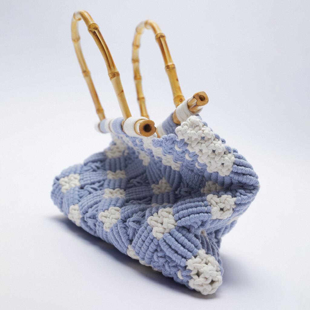 A handcrafted, lightweight bag with bamboo handles, featuring a textured blue and white woven pattern, displayed against a plain white background.