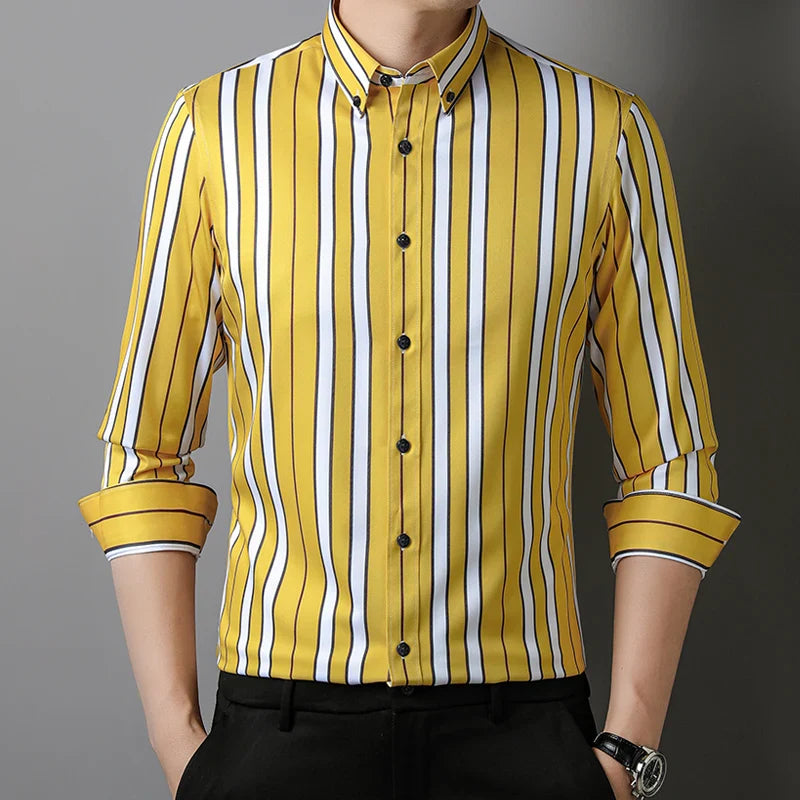 A man wearing the Hamilton Executive Classic Fit Shirt in spring colors—a yellow button-up with vertical black and white stripes, sleeves rolled up, and paired with black pants.