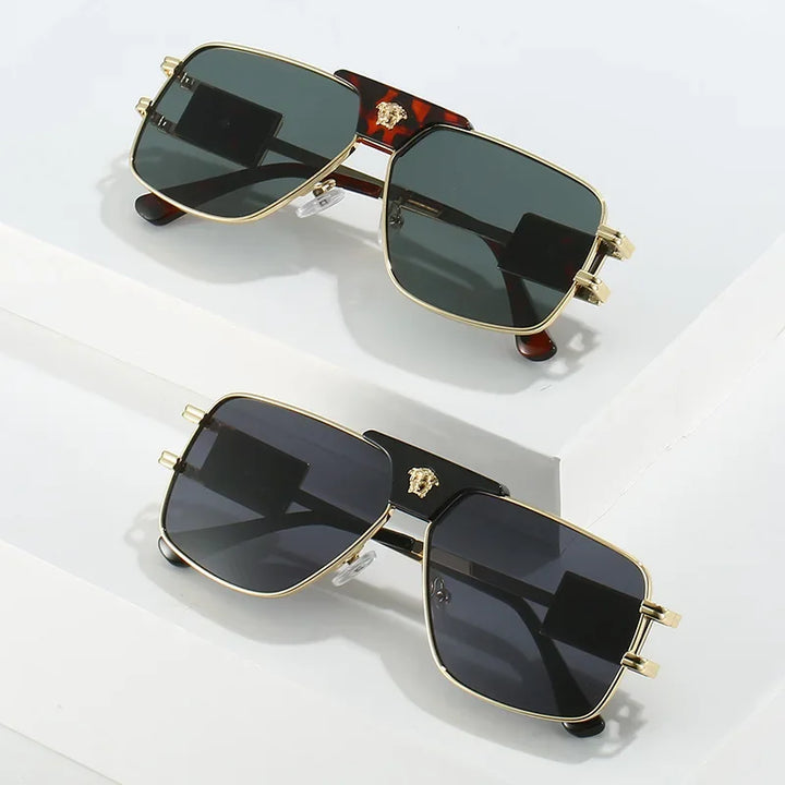 Two pairs of bold sunglasses with premium metal frames and gold emblems sit on a white surface. Their stylish rectangular design features dark lenses that offer UV400 protection for your eyes.