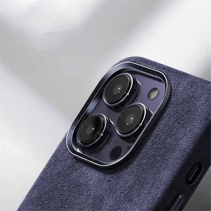 Close-up of the rear camera module of a smartphone with three lenses, shown in a dark blue textured case featuring a suede finish against a light background.