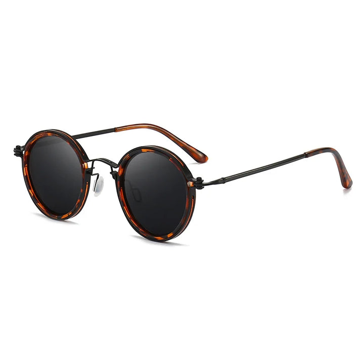 Round Ruby Ray Sunglasses with dark lenses, tortoiseshell-patterned frames, and black metal arms with matching tips. Featuring UV400 protection, they’re stylishly angled with one arm extended outward.
