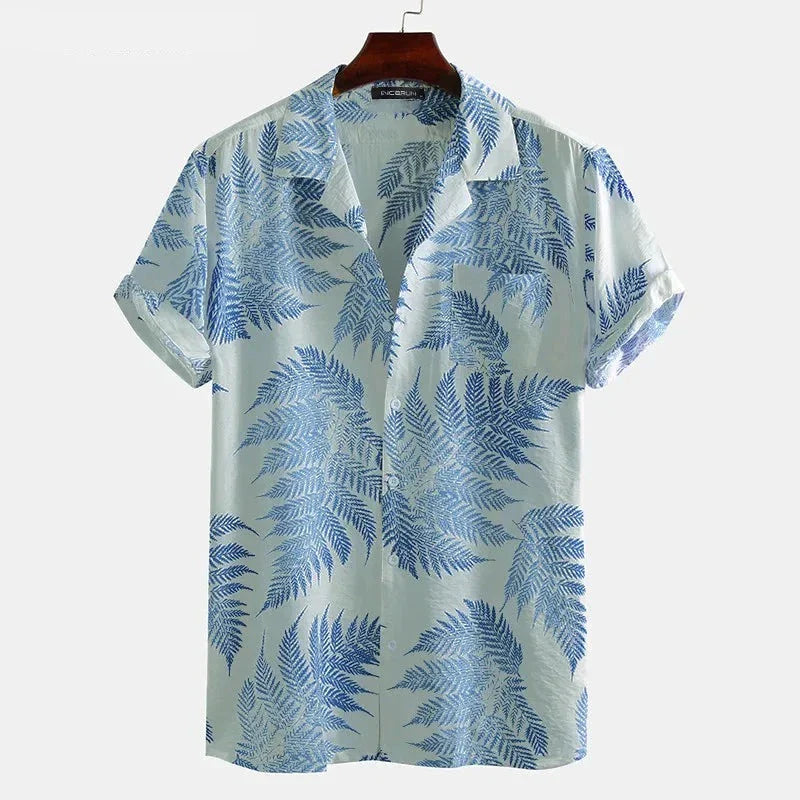 A light blue cotton shirt with short sleeves and a classic design, featuring blue fern leaves. This button-up collared shirt is displayed on a wooden hanger against a plain white background—perfect for a casual brunch.