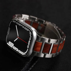 A modern smartwatch with a black screen, white digital numerals, and a red second hand, featuring a silver and sandalwood watch band, rests elegantly on a dark surface.