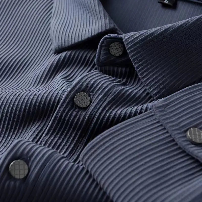 Close-up of a dark blue breathable shirt with ribbed, textured fabric. The ultra soft fabric and black buttons with a subtle grid pattern are showcased, highlighting the shirt’s comfort, detailed texture, and button design.