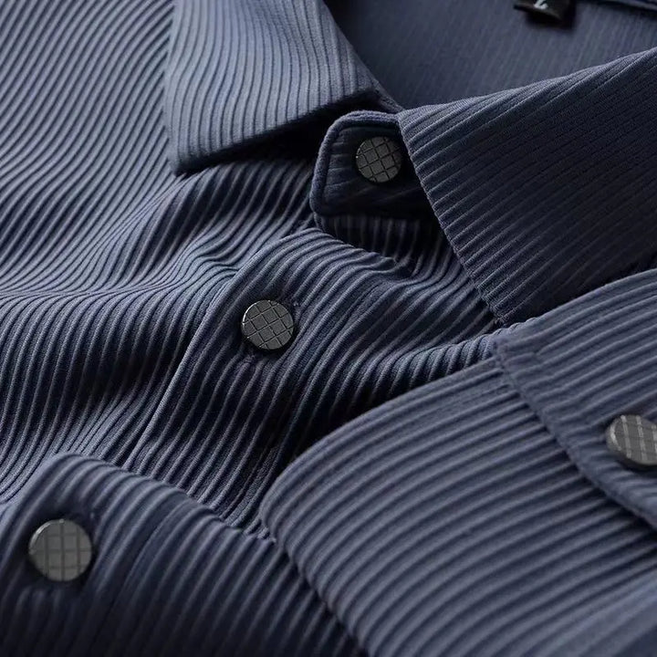 Close-up of a dark blue breathable shirt with ribbed, textured fabric. The ultra soft fabric and black buttons with a subtle grid pattern are showcased, highlighting the shirt’s comfort, detailed texture, and button design.
