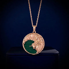 Gold chain necklace with a round pendant featuring a raised angel design over a green background, displayed against a dark backdrop—a unique piece of astrology jewelry.