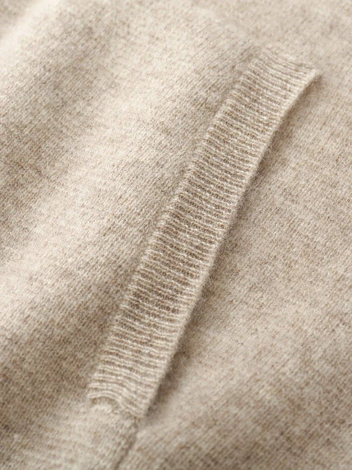 Close-up of a soft, beige knit fabric with a ribbed pocket detail. The texture appears smooth and cozy, perfect for an autumn winter cardigan or classic men wool cardigan ideal for chilly days.