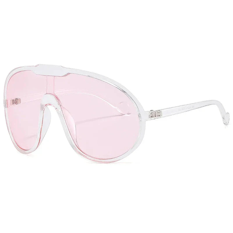 Clear-framed oversized sunglasses with a single large pink-tinted lens offer UV400 protection, featuring a curved shield design and thin, transparent arms—perfect for stylish outdoor activities.