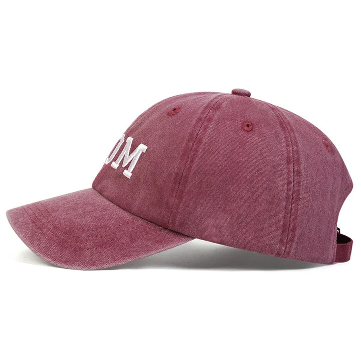 A maroon embroidered cap with visible stitching, white letters partially reading UM, and an adjustable strap at the back, shown in a side profile view against a white background—a classic Mom & Dad cap with vintage streetwear flair.