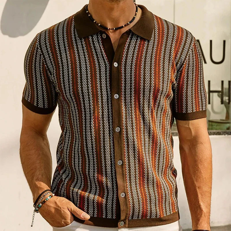 A man wears a short-sleeve button-up shirt with a brown collar and cuffs, featuring vertical stripes in brown, orange, and white zigzag jacquard herringbone patterns. He also accessorizes with a beaded necklace and bracelets.