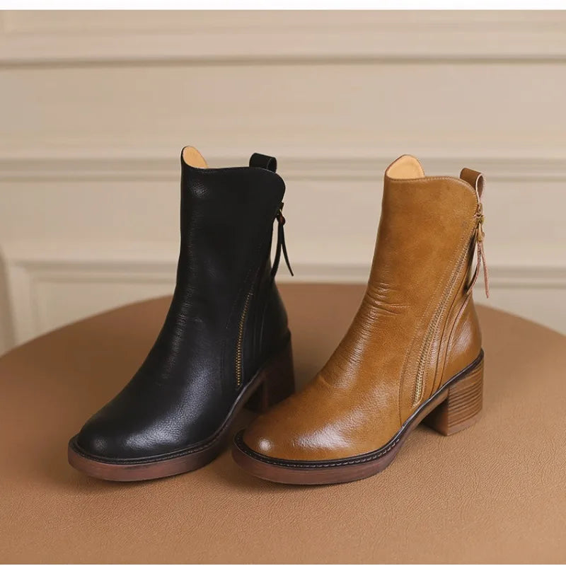 A pair of women’s ankle boots—one black and one tan—both with side zippers and medium block heels, placed side by side on a brown surface against a beige background, perfect as stylish winter boots.