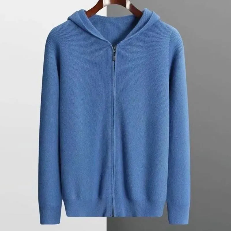 A blue, zip-up hoodie with long sleeves, crafted from luxurious cashmere, is displayed on a hanger against a background split between white and gray.
