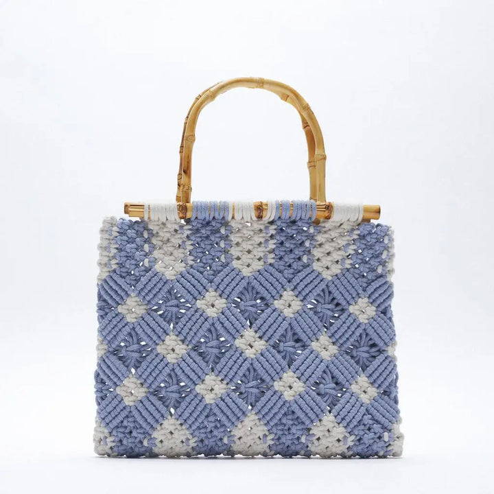 A square-shaped macramé handbag with a woven blue and white diamond pattern and two curved bamboo handles, displayed against a plain white background.
