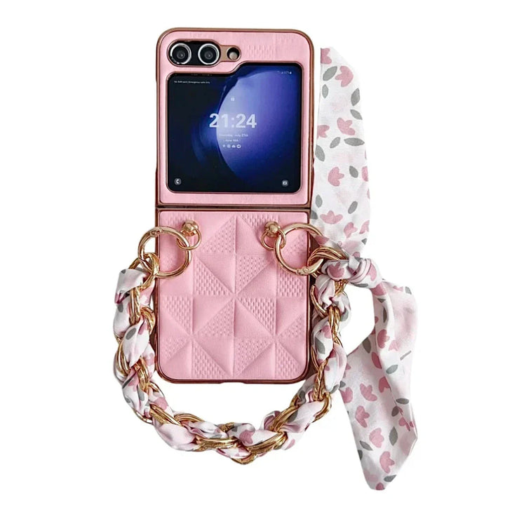 A pink premium leather case for the Samsung Galaxy Z Flip, featuring a quilted pattern, gold rings, a chain handle with a floral scarf, and shockproof protection. The screen displays the time 21:24.