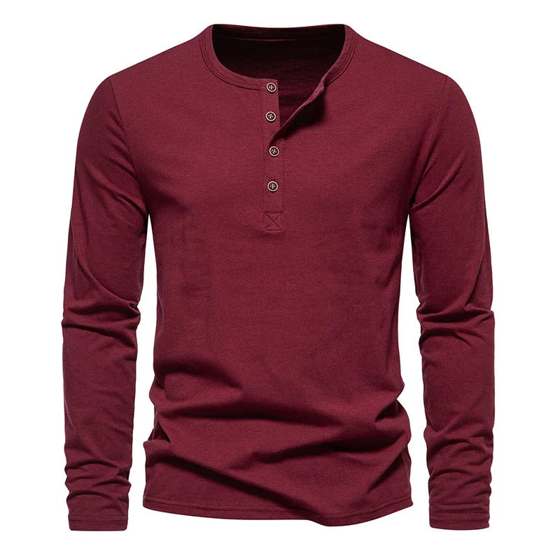 A long-sleeved, maroon Henley shirt with a classic design, featuring a round neckline and four buttons down the front placket, displayed against a white background.