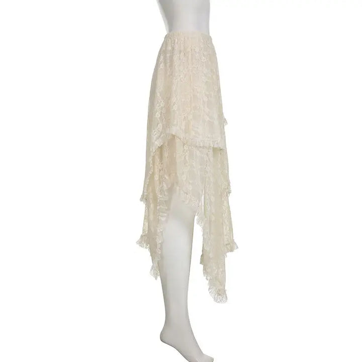 A mannequin displays an off-white, high-low lace skirt with a high waist and asymmetrical hemline. Featuring layered, ruffled details, the silky lace fabric appears lightweight and semi-sheer.