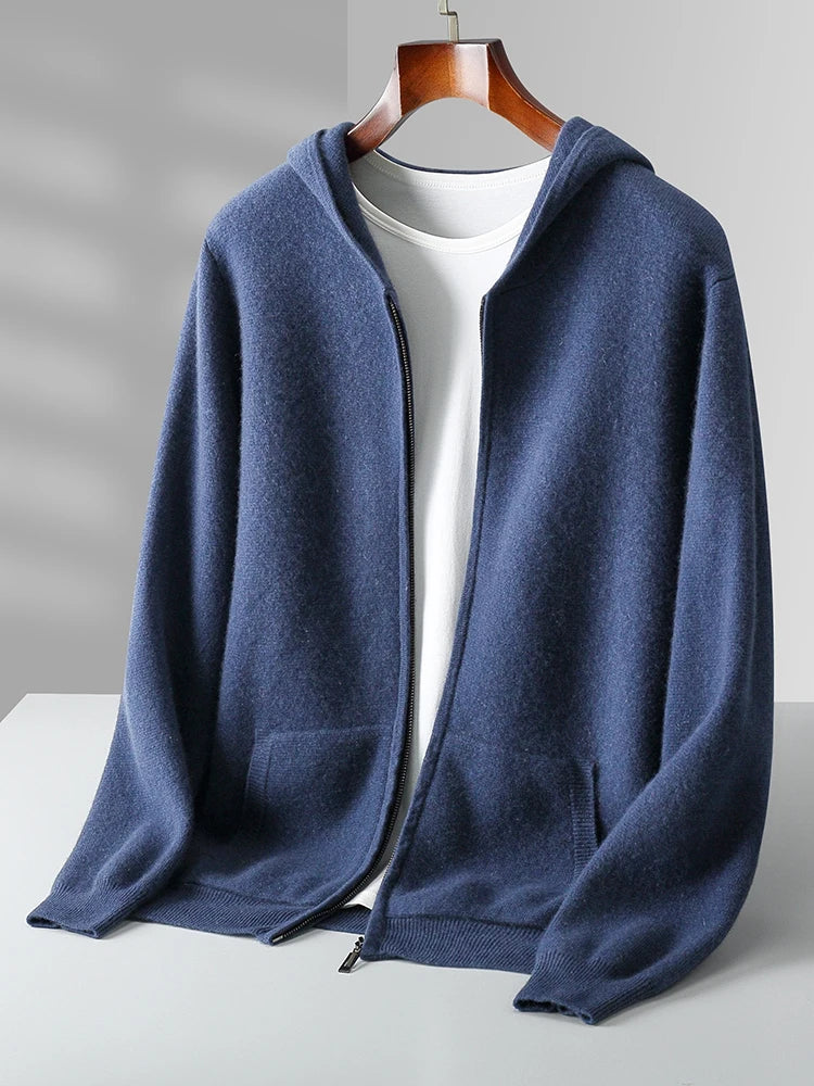 A blue zip-up hoodie with a hood and front pockets is displayed on a hanger over a plain white T-shirt, evoking the cozy feel of an autumn winter cardigan, set against a light gray background.