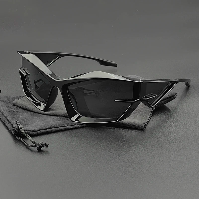 A pair of futuristic, angular black cycling glasses with UV400 protection and dark, high-contrast lenses rests on a matching black drawstring pouch against a smooth, dark background.