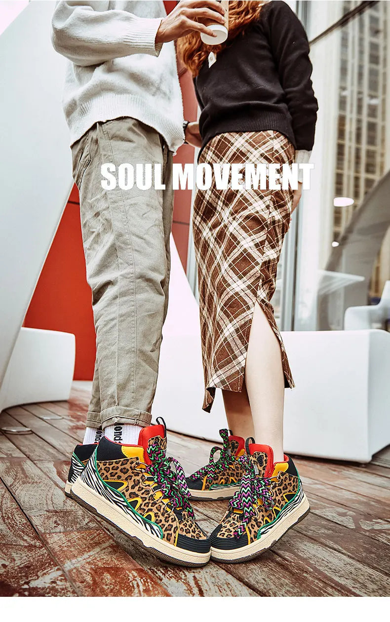Two people face each other indoors; one in khaki pants, the other in a plaid skirt with a slit. Both wear lightweight animal print shoes. The words SOUL MOVEMENT appear in large white text over the image.