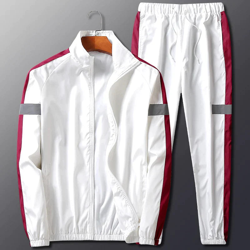 A white two-piece activewear set with maroon side stripes and gray reflective bands on the sleeves and pant legs, displayed on a hanger against a gray background. The jacket is unzipped and features a stand-up collar.
