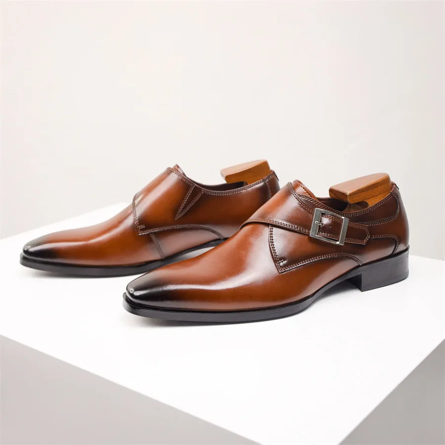 A pair of polished brown Italian leather monk strap dress shoes with silver buckles and wooden shoe trees, displayed on a white surface against a light background.