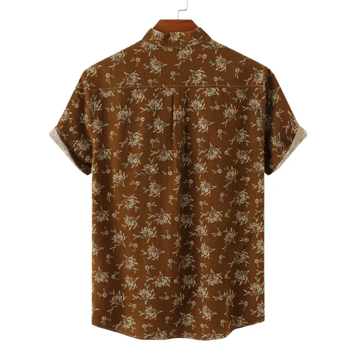A brown short-sleeve cotton shirt with a small, light-colored floral print, displayed on a hanger with the back side facing forward—a casual shirt perfect for relaxed days.