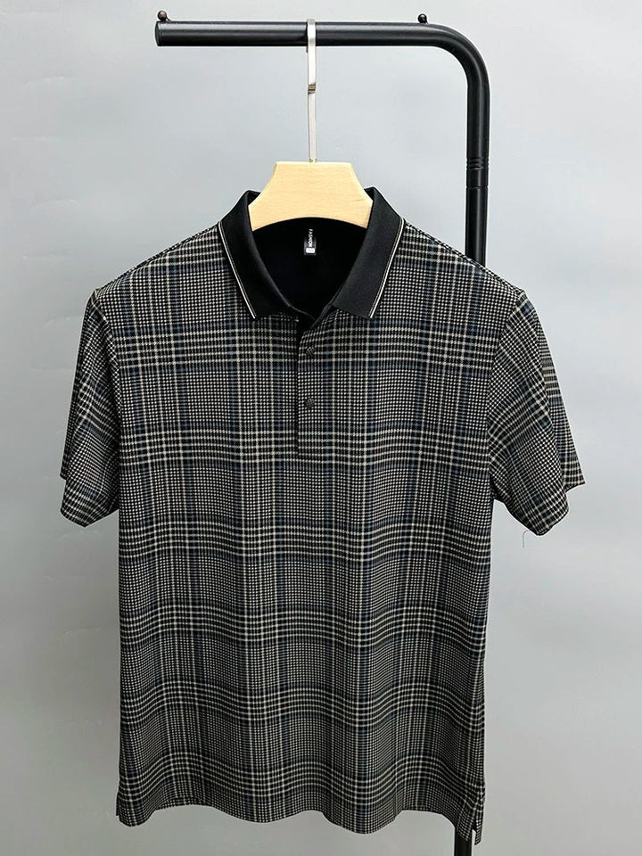 A short-sleeved, black and white plaid polo shirt with a breathable black collar, displayed on a wooden hanger against a plain light gray background.