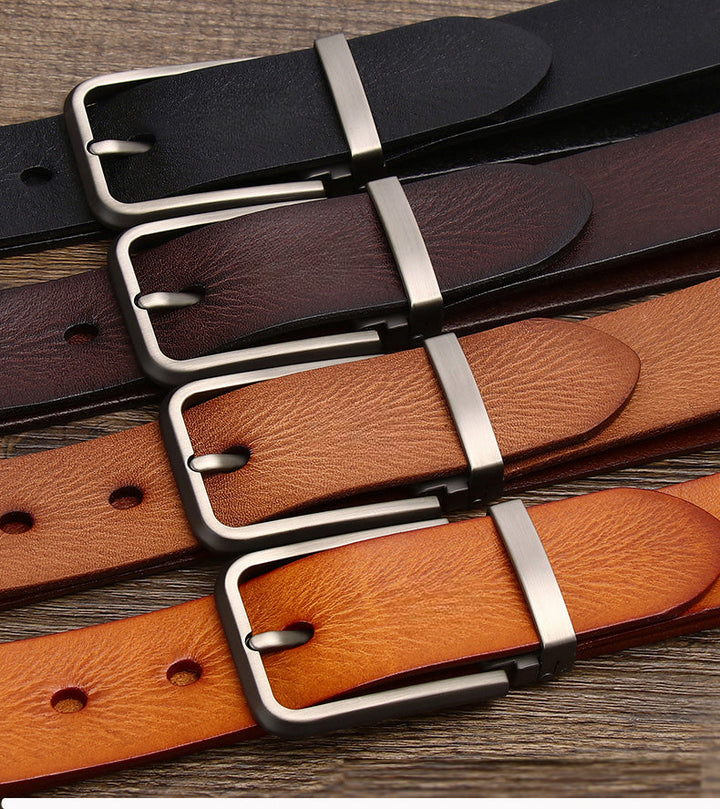 Four leather belts in black, dark brown, brown, and tan, each cowhide belt featuring a silver rectangular buckle, are laid out parallel on a wooden surface.