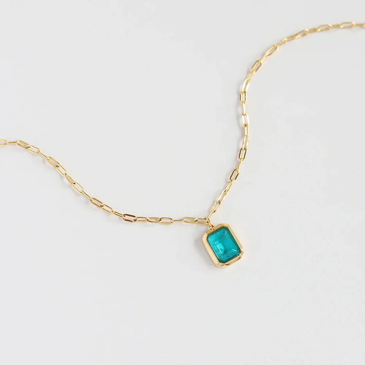 A delicate 18K gold plated chain necklace with a rectangular green zirconia pendant set in a gold frame, displayed on a white background.