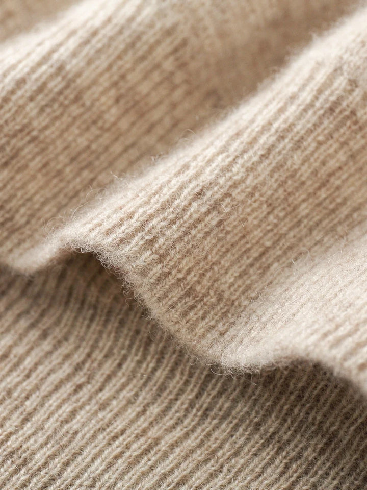 A close-up of soft, beige ribbed fabric with visible texture and gentle folds, highlighting the cozy and warm appearance perfect for an autumn winter cardigan.