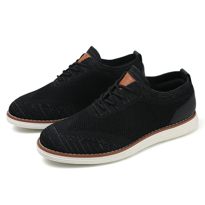 A pair of black breathable knit sneakers with white soles, light brown detailing near the laces, and a sleek, casual style perfect for everyday wear.