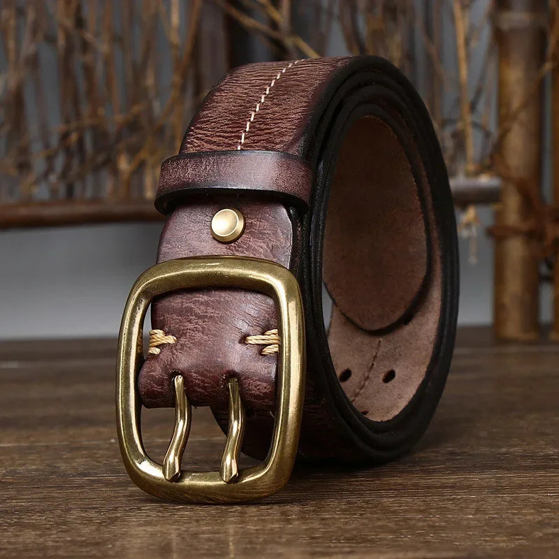 A brown genuine leather belt featuring a gold buckle, crafted with heritage craftsmanship.