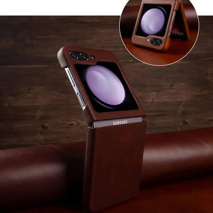 A Samsung Galaxy Z Flip in a genuine leather brown case stands upright on a brown surface, its outer screen displaying a purple sphere. An inset highlights a close-up of the phone’s outer screen and camera area.