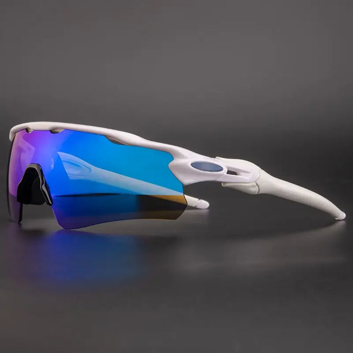 A pair of white polarized cycling sunglasses with a single, curved, reflective blue lens offers UV protection, displayed against a plain dark gray background.