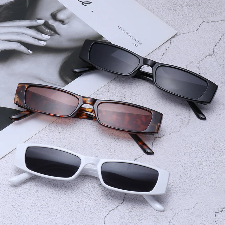 Three pairs of retro rectangle sunglasses in black, tortoiseshell, and white frames are displayed on a textured surface next to a monochrome magazine featuring a womans face and hand. All feature lightweight frames and UV400 protection.