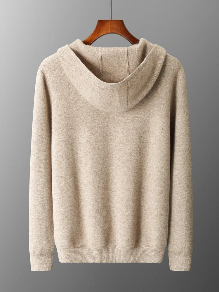 A beige hooded sweatshirt hangs on a wooden hanger against a gray background, shown from the back with long sleeves and ribbed cuffs and hem—perfect as an autumn winter sweater for casual warmth.