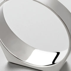 A close-up view of a modern, minimalist silver bracelet crafted from scratch-resistant stainless steel with smooth, reflective surfaces, photographed against a light gray background.