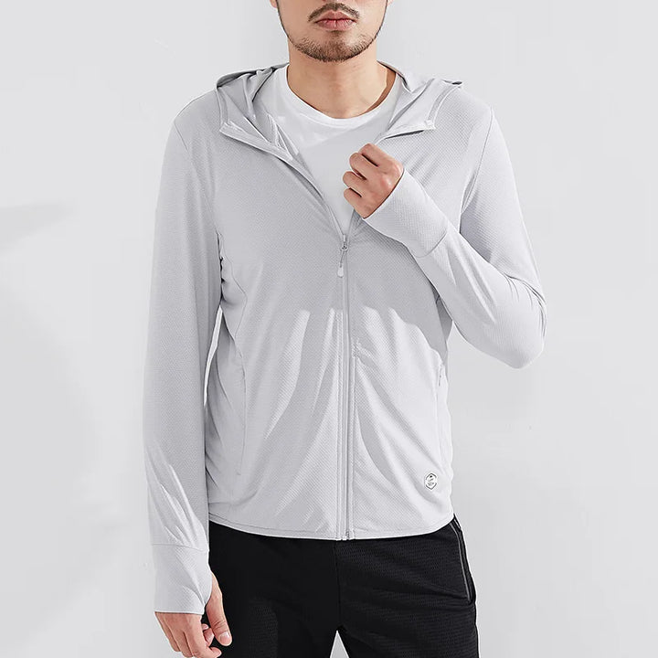 A man wearing a light gray zip-up hoodie with UPF 50+ sun protection over a white t-shirt and black pants stands against a plain white background. The hoodie features a hood, thumb holes on the sleeves, and quick-drying fabric.