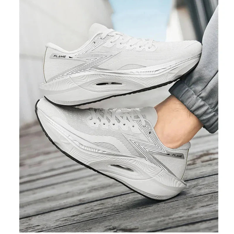 A person wearing light gray athletic sneakers with a shock-absorbing sole stands on a wooden surface, one foot slightly raised. The shoes have FLAME printed on the side and feature a sleek, modern design.