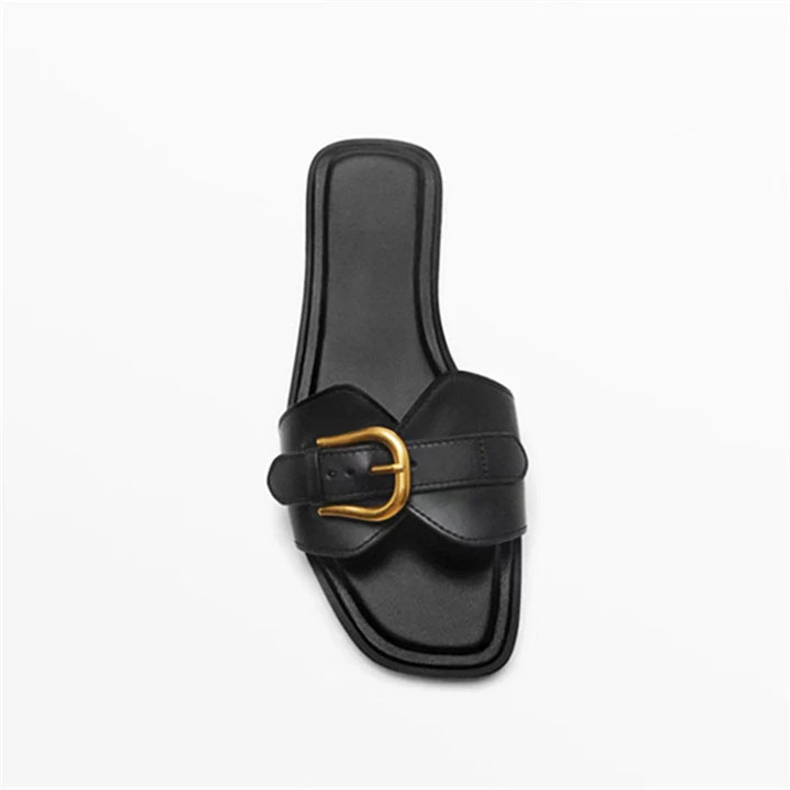 A single black leather slide sandal with a square toe and a wide strap across the front, featuring a gold buckle detail, displayed on a white background.