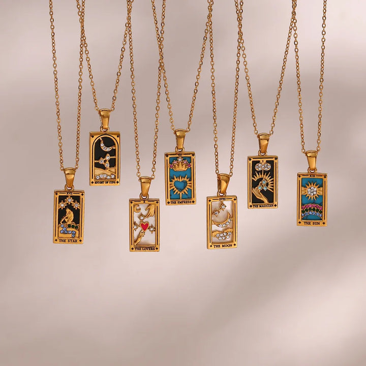 Seven 18K gold-plated Solaris Pendant Necklaces feature rectangular pendants, each with a colorful tarot card design like The Sun and The Moon, adorned with accents such as blue enamel for a unique, mystical touch.