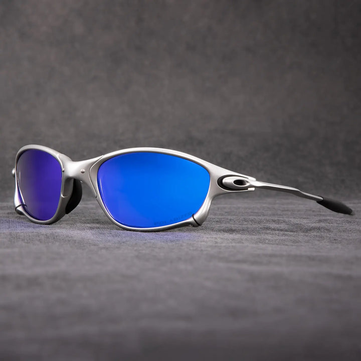 A pair of silver-framed polarized sunglasses with blue mirrored lenses is displayed on a textured gray surface, with a dark gray background—perfect outdoor eyewear offering stylish UV protection.