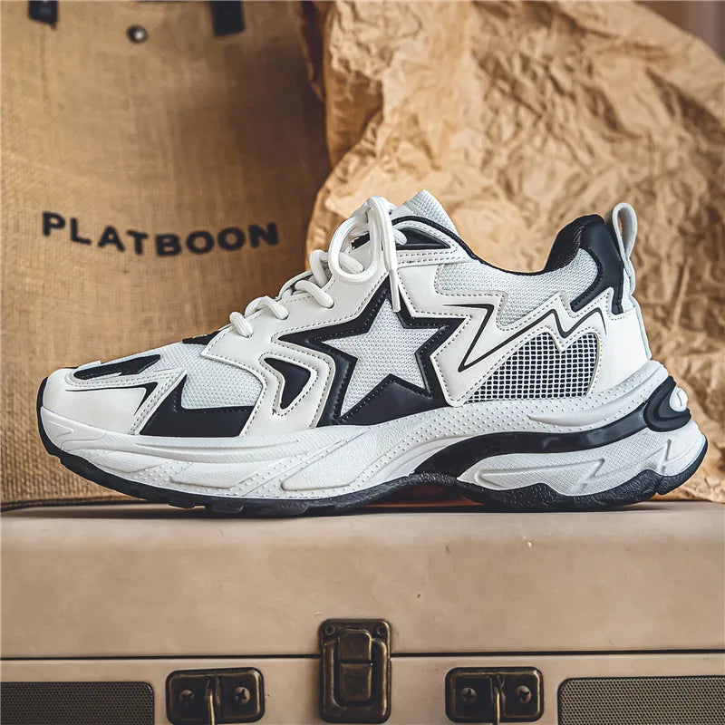 A stylish white sneaker with black accents, a star design on the side, and chunky sole features a durable rubber outsole. Displayed on a suitcase with a beige textured background, the word PLATBOON is partially visible.