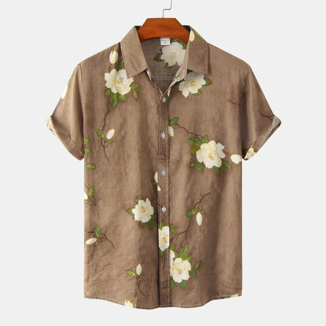 A brown short-sleeve floral shirt with white flowers and green leaves, perfect for summer style, displayed on a wooden hanger against a plain white background.